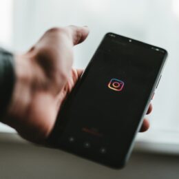 person holding black android smartphone with instagram boot screen loading up