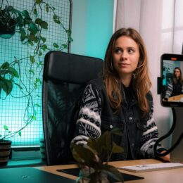 a female content creator working in an office and making videos.