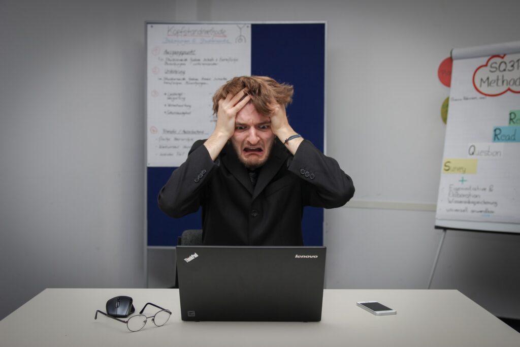 a frustrated man on his black laptop experiencing creative block