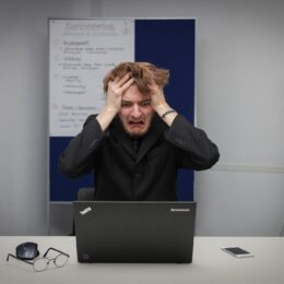 a frustrated man on his black laptop experiencing creative block
