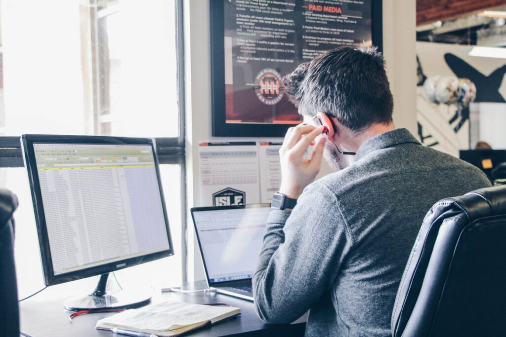 Man performing social listening research on a laptop in an urban office