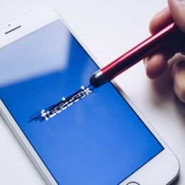 pencil erasing lines on an iPhone screen showing the Facebook logo